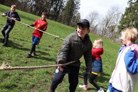 Das Bidl zeigt Kinder, die an einem dicken Seil ziehen. Sie lachen. Im Hintergrnd ist der Albtrauff zu sehen.