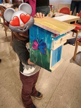 Kind hält Nistkasten hoch