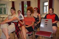 Tänzerinnen sitzen auf Stühlen