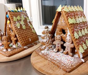 Ein leckeres Bild eines Plätzchenhauses mit bunten Streusel und Lebkuchen Männchen vor dem Haus.