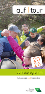 Gruppe von Menschen in Outdoor-Kleidung, die sich die Hände reichen, darüber Text 'auf | tour', darunter '2026' und 'Jahresprogramm Lehrgänge und Freizeiten'.